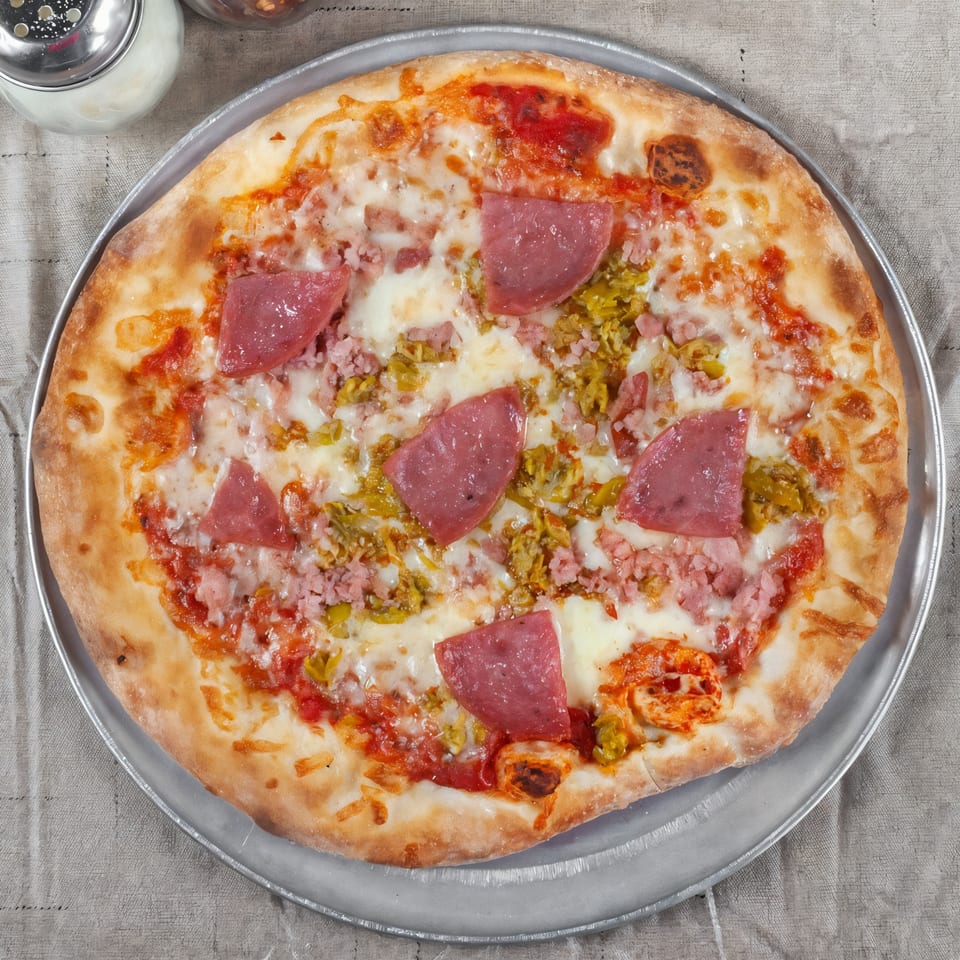 Luisa's Brick Oven Pizzeria's pizza with salami, ground meat, and green peppers on a metal pan.