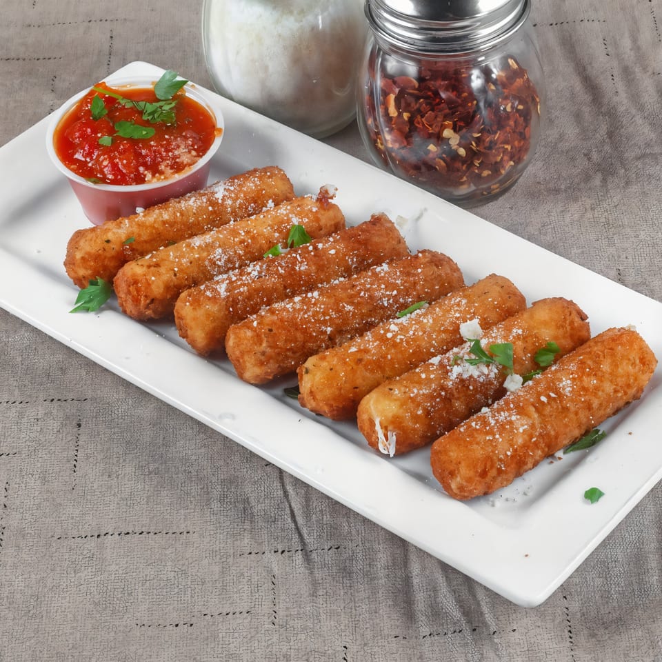 Golden-brown mozzarella sticks with parmesan and parsley, served with marinara sauce, salt, and red pepper flakes.